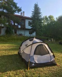 Daday的住宿－Balabanağa Çiftliği Camping，坐在房子前面的草上的一个帐篷