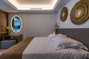 a bedroom with a large bed and a mirror at Tasia Maris Beach Hotel - Adults Only in Ayia Napa