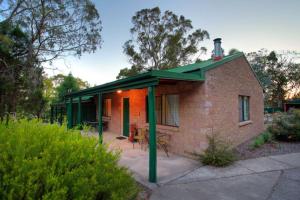 a small brick house with a green roof at Murray Gardens Motel in Stanthorpe +25 photos