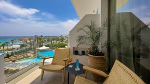 a balcony with chairs and a view of a resort at Tasia Maris Beach Hotel - Adults Only in Ayia Napa