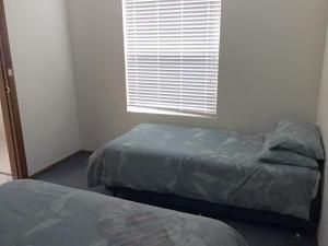 a bedroom with two twin beds and a window at Beach Front with Amazing Ocean Views in Victor Harbor +4 photos
