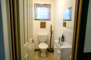 a white bathroom with a toilet and a sink at Luxury Pumicestone Cottage - Beach Charm - ZA7 in Golden Beach +32 photos