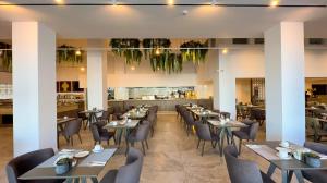 a restaurant with tables and chairs and a bar at Tasia Maris Beach Hotel - Adults Only in Ayia Napa