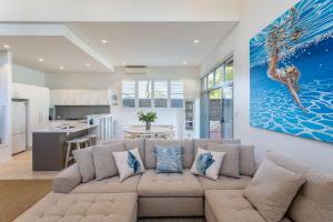Una sala de estar con un sofá y una cocina. en Bay Watch I Private Properties, en Dunsborough