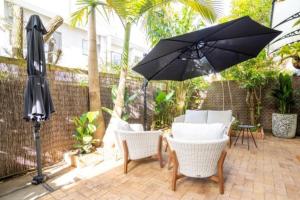 une terrasse avec une table, des chaises et un parasol dans l'établissement Fantastic central location, à Noosaville