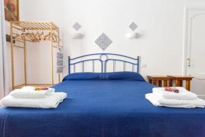 Un dormitorio con una cama azul con toallas. en ALESSANDRAB&B, en Lipari