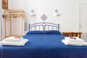 ein Schlafzimmer mit einem blauen Bett mit Handtüchern darauf in der Unterkunft ALESSANDRAB&B in Lipari