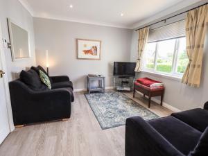 Sala de estar con 2 sofás y TV en Fairview en Bowness-on-Windermere