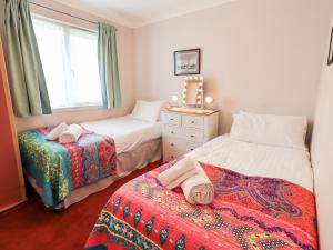 1 dormitorio con 2 camas y ventana en Fairview en Bowness-on-Windermere