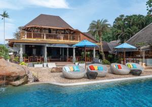 un complejo con piscina con sillas y sombrillas en Tinkerbell Resort @ Koh Kood, en Ko Kood