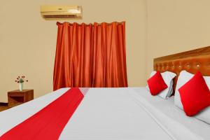 uma cama com almofadas vermelhas e uma cortina vermelha em park 9 em Ameerpet