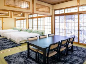 a bedroom with a bed and a table and chairs at グランピング　星が見の杜 in Nakatsugawa