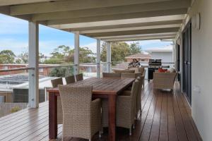 an outdoor deck with a wooden table and chairs at Cowes Family Haven in Cowes