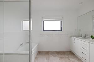 Un baño blanco con ducha y lavabo. en Cowes Family Haven, en Cowes 12 fotos más