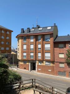 a large brick building on the side of a street at Apartamento junto al parque in Ponferrada