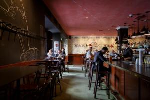 eine Gruppe von Personen, die in einer Bar in einem Restaurant sitzen in der Unterkunft The Hotel Windsor in Melbourne