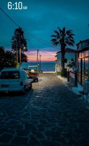 a white car parked on a street near the ocean at Efterpi Aggeli in Loutrópolis Thermís