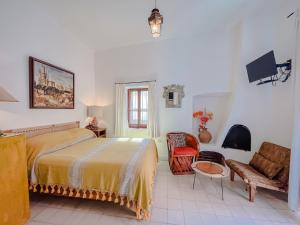 a bedroom with a bed and chairs in it at Mansion del Bosque in San Miguel de Allende