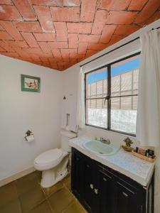 a bathroom with a toilet and a sink and a window at Mansion del Bosque in San Miguel de Allende