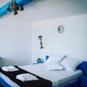 uma cama com almofadas brancas e um relógio na parede em Casa Dima Sarichioi em Sarichioi