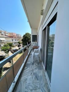 a balcony with a chair and a view of a city at P & P Apartment in Alexandroupoli