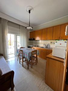 une cuisine avec une table et une cuisine avec une salle à manger dans l'établissement P & P Apartment, à Alexandroúpolis