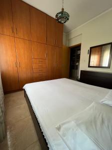 una camera con un grande letto e armadi in legno di P & P Apartment a Alexandroupoli