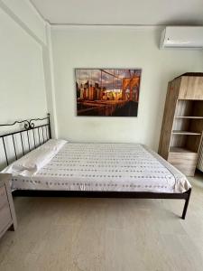 a bedroom with a bed and a painting on the wall at P & P Apartment in Alexandroupoli