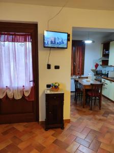 un soggiorno con tavolo e TV a parete di L'Appartamentino a Lucca