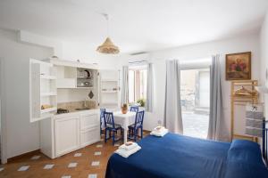a bedroom with a blue bed and a table with chairs at ALESSANDRAB&B in Lipari