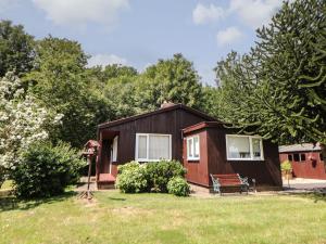 a small cabin in a yard with a grass field at Cedar Holme in Chesterfield