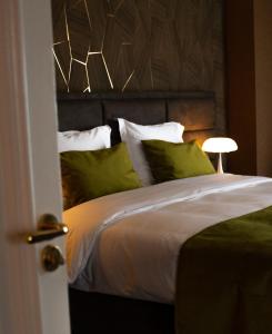 a bedroom with a large bed with green pillows at Hotel & Restaurant Infinity in Lichtmis