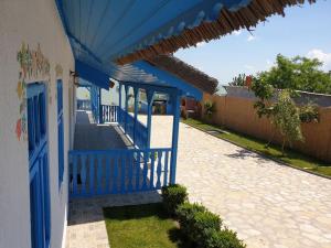 um edifício azul com um telhado azul e um passeio em Casa Dima Sarichioi em Sarichioi