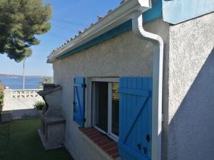 une porte bleue sur le côté d'une maison dans l'établissement Maison T3 avec vue au bord de l’étang, à Istres