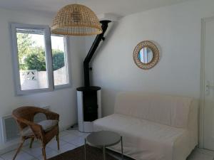 a living room with a white couch and a window at Maison T3 avec vue au bord de l’étang in Istres