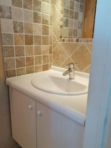 uma casa de banho com um lavatório branco e um espelho. em Maison T3 avec vue au bord de l’étang em Istres