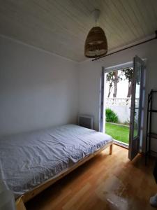 um quarto com uma cama e uma porta de vidro deslizante em Maison T3 avec vue au bord de l’étang em Istres