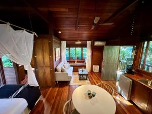 a living room with a table and a couch and a kitchen at Koompartoo Retreat Bellingen in Bellingen