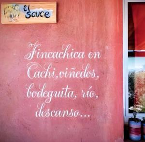 a sign on the side of a red wall at Fincachica in Cachí