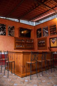 un bar con sillas y una barra con botellas de vino en Hotel El Patio, en Tequisquiapan