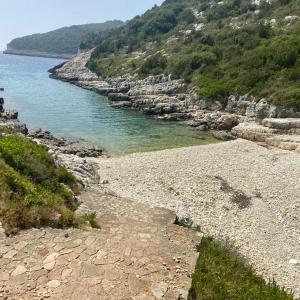 uma costa rochosa com uma massa de água em Aphrodite's hidden gem on Paxos island em Velianitátika