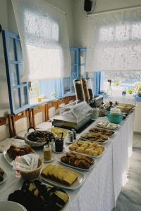 イオス島 チョーラにあるHotel Petradiのテーブルの上に様々な種類の料理を揃えたビュッフェ