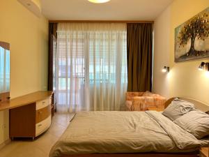 a bedroom with a bed and a large window at Premium Apartment Midia Beach in Sunny Beach