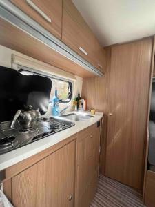 uma cozinha com um fogão e um lavatório num trailer em Boende i centrala Kungshamn em Kungshamn