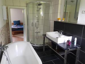 a bathroom with a tub and a sink and a shower at Ferienwohnung Südheide in Beedenbostel