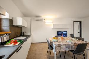 cocina con mesa con sillas y comedor en Appartamento Borgo Pastoedo - Happy Rentals en Tenno
