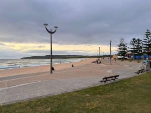 a beach with a street light and people on the beach at Private 1 bedroom apartment near beach and shops in Sydney