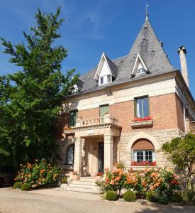 ein großes Backsteinhaus mit steilem Dach in der Unterkunft Villa Les Iris in Saint-Félix