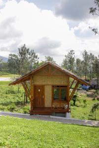 蘇邦的住宿－Villa Kahuripan Smart Hill Camp，草场上带屋顶的小建筑