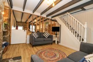a living room with a staircase and a couch at Walter in Penzance